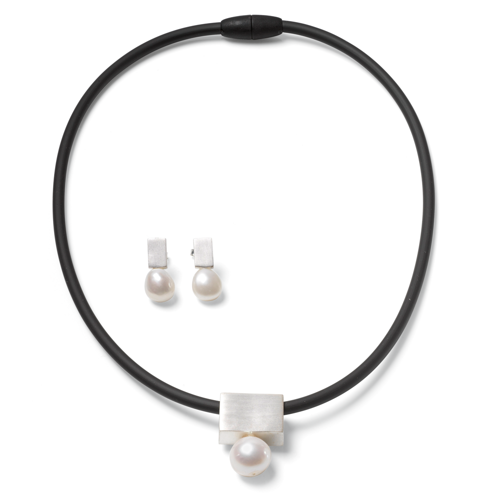 Schmuckset „Mother of Pearl“ (silber): Schwarzes Choker-Halsband und passende Perlen-Ohrringe mit silbernen Akzenten auf weißem Hintergrund.
