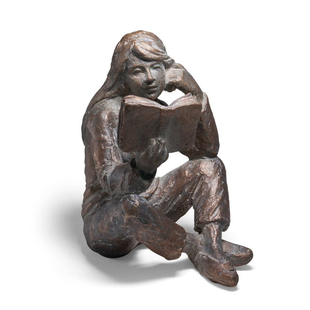 Die Bronzeskulptur „Lesende“ von Luis Höger stellt eine sitzende Person mit einem Buch dar, den Kopf auf eine Hand gestützt.