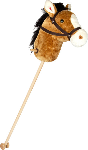 Das Steckenpferd „Nico“ ist ein braun-weißes Plüsch-Steckenpferd auf einem Holzstab mit schwarzer Mähne und Zaumzeug.
