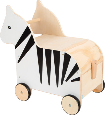 Die Spielzeugkiste mit Rollen Zebra „Wildlife“ ist ein Rutscher aus Holz in Form eines Zebras mit Staufach, vier Rädern und einem Holzgriff.