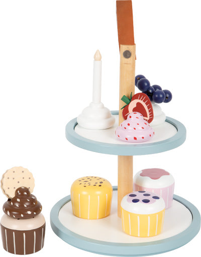 Die Cupcake Etagere „tasty“ ist ein bemalter Dessertständer aus Holz mit pastellfarbenen Cupcakes, Obst und einer Kerze.
