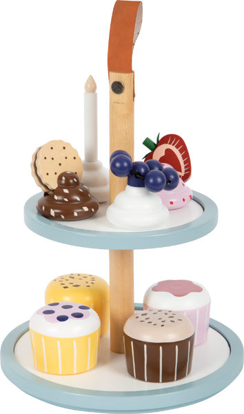 Die Cupcake Etagere „tasty“ ist ein zweistöckiger Spielzeug-Dessertständer mit Kuchen, Gebäck und einer Kerze aus Holz, gekrönt von einem braunen Griff.