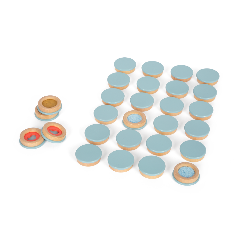 Das Fühlmemo-Set „Sensory“ enthält 24 runde Holzscheiben mit blauen Oberseiten, von denen einige gedreht sind, um strukturierte Oberflächen zum taktilen Erkunden freizugeben.