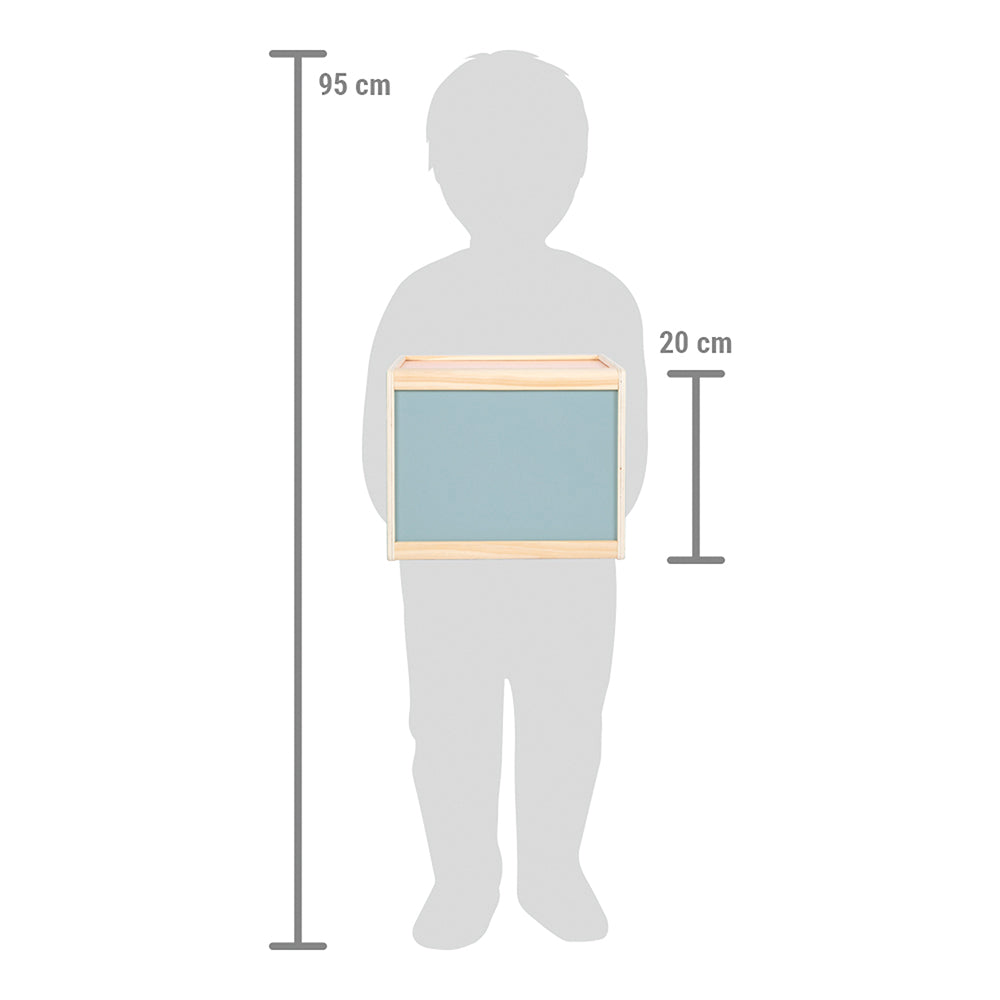 Eine 95 cm große Kindersilhouette hält die Fühlbox „Sensory“, eine 20 cm hohe rechteckige Box mit blauer Vorderseite und Holzkanten.