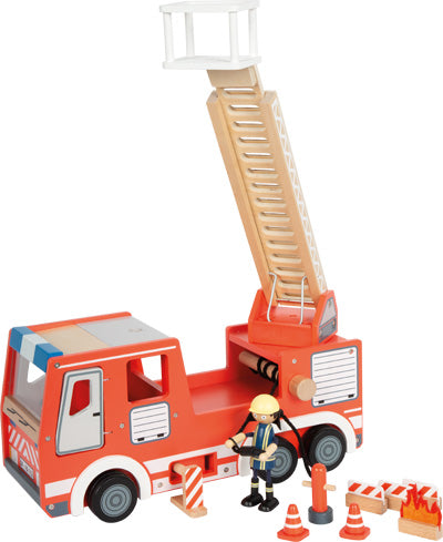 Spielzeug-Feuerwehrauto mit ausgefahrener Leiter, Feuerwehrmann-Figur, Verkehrsleitkegeln und Straßenabsperrungen.