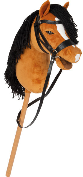 Ein braunes Steckenpferd aus Plüsch mit schwarzer Mähne, weißen Gesichtszügen, Zaumzeug und einem Holzgriff.