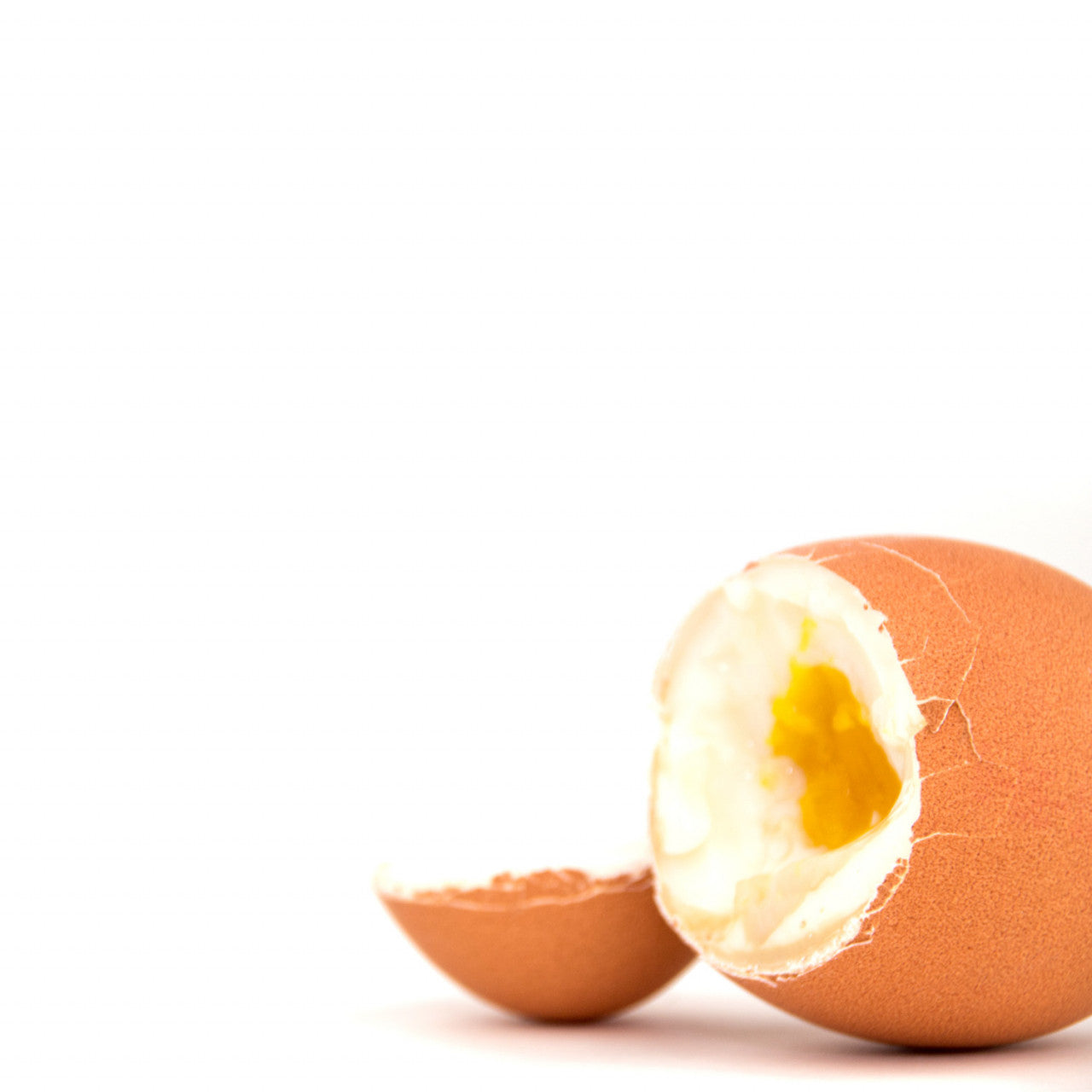 Das Goldene PiepEI, ein halb aufgegessenes gekochtes Ei mit kaputter Schale, ist auf weißem Hintergrund abgebildet.