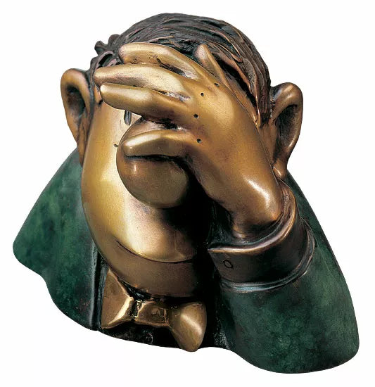 Die Bronzeskulptur „Der Optimist“ von Loriot zeigt eine Comicfigur, die ihr Gesicht mit einer Hand in klassischer Facepalm-Manier verdeckt und einen verzweifelten Gesichtsausdruck hat.
