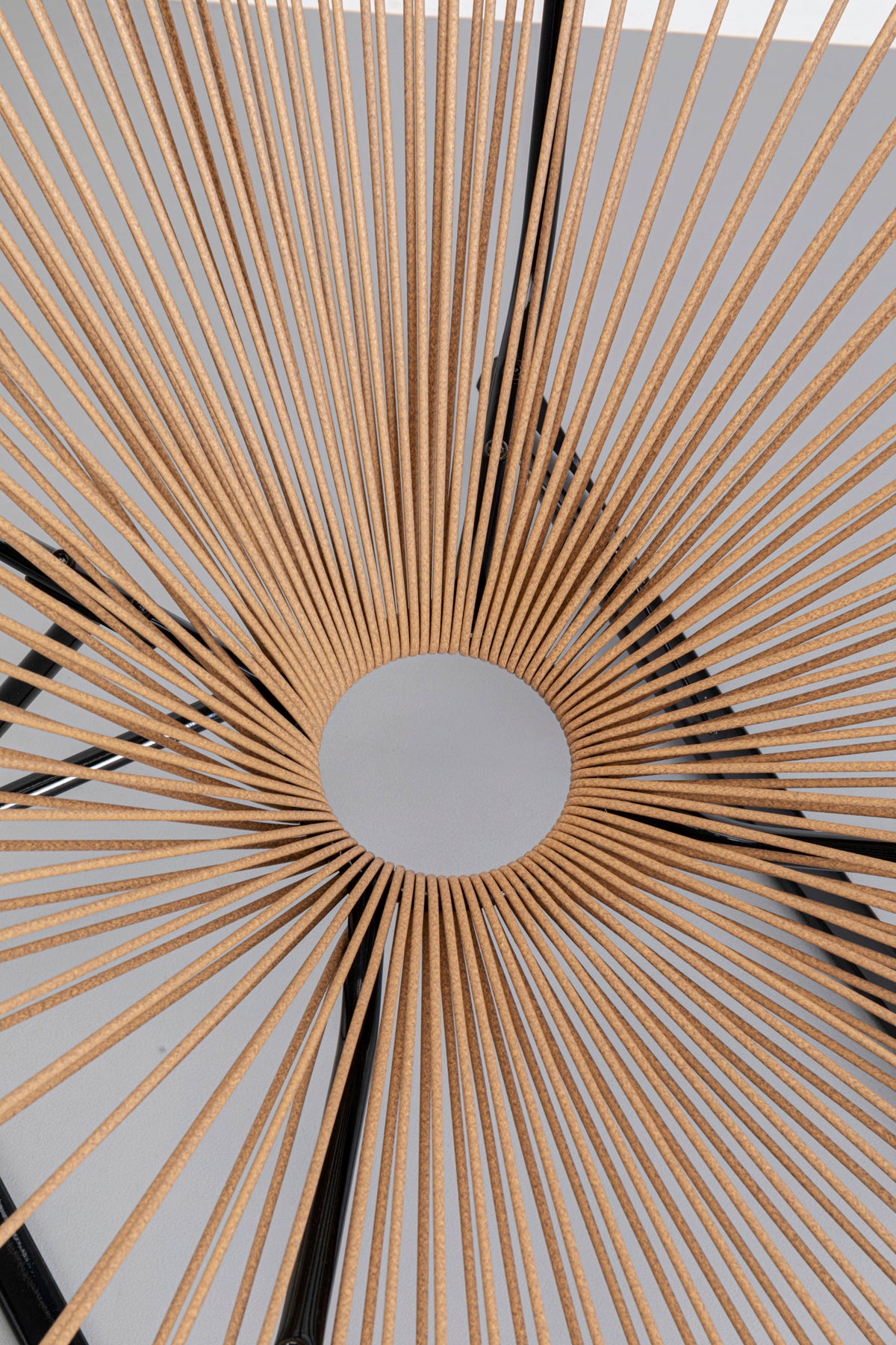 Der Schaukelstuhl Acapulco in Schwarz oder Natur verfügt über ein sonnenstrahleninspiriertes Design mit dünnen, gleichmäßig verteilten Lamellen, die für einen dynamischen, geometrischen Look sorgen und an den klassischen Acapulco-Stil erinnern.