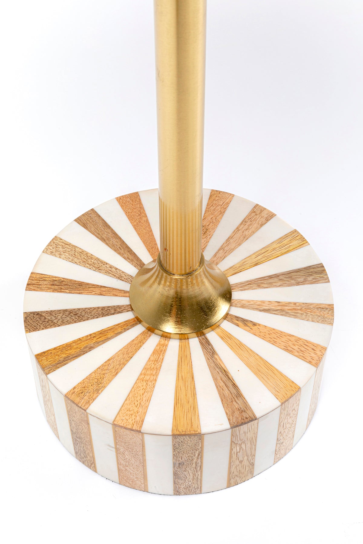 Eine Nahaufnahme des Beistelltischs Domero Cirque Gold Weiß Ø40cm, der seine runde Tischplatte mit abwechselnden Holz- und Weißstreifen und einer goldbeschichteten Metallstange zeigt, die aus der Mitte ragt.