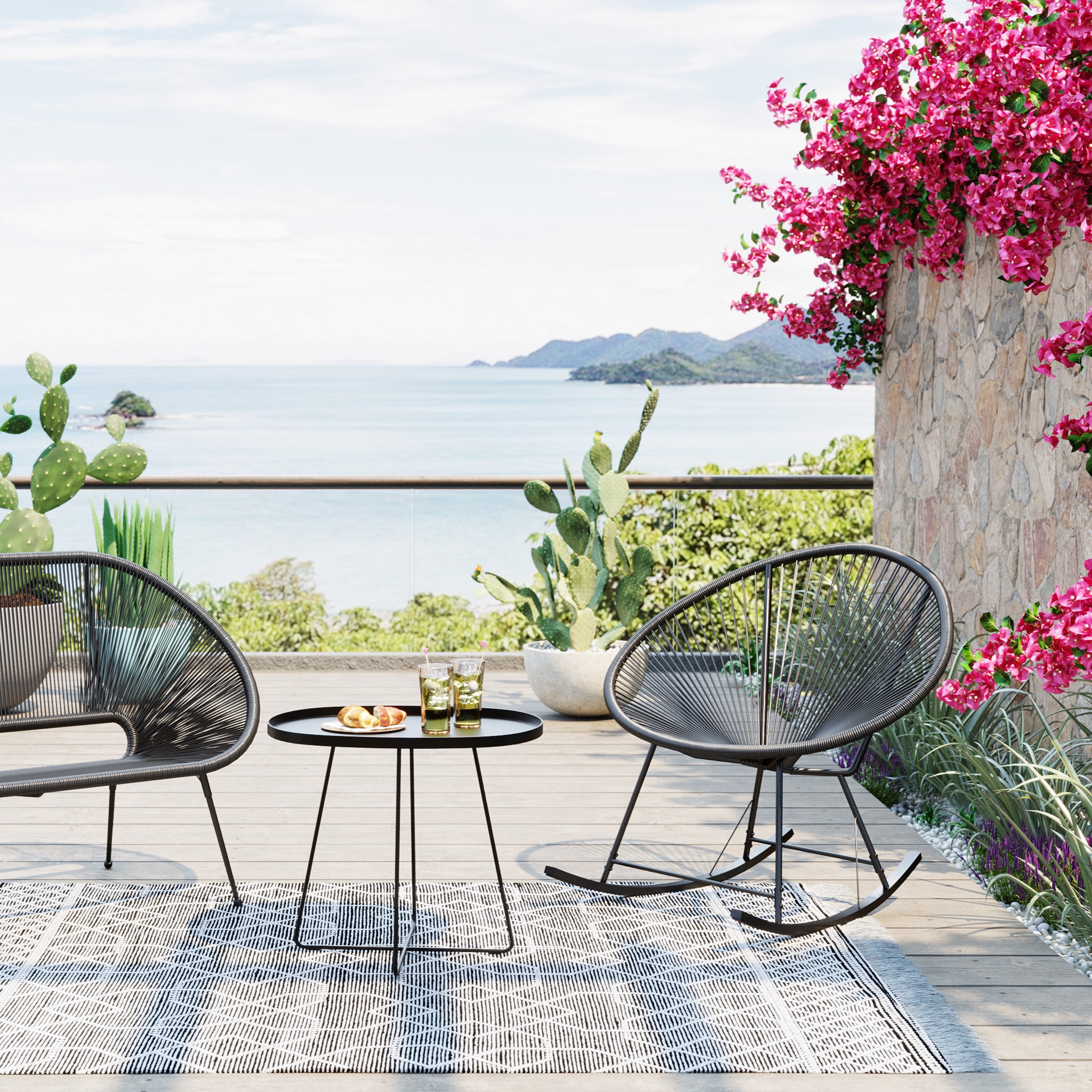 Eine Terrasse mit dem Schaukelstuhl Acapulco in Schwarz oder Natur und einem Tisch schafft einen stilvollen Rückzugsort im Freien.