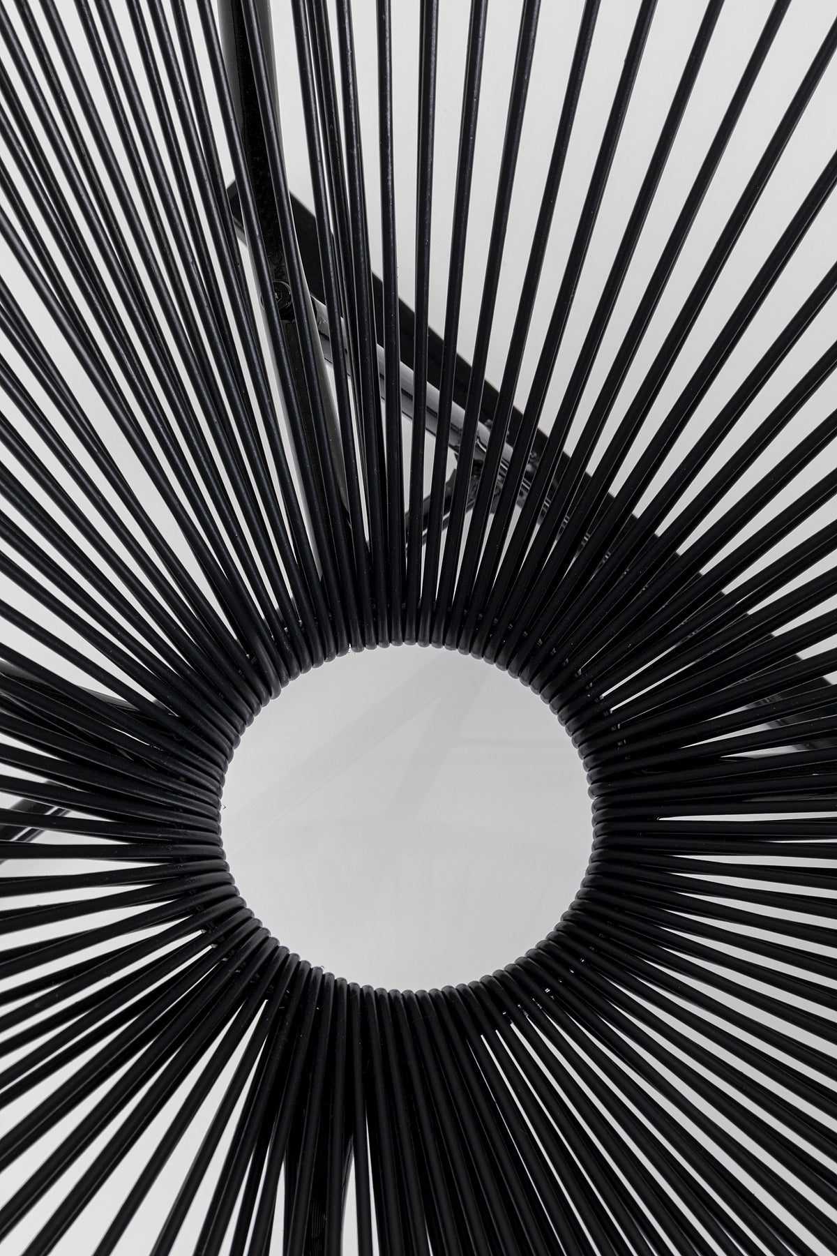 Nahaufnahme des Schaukelstuhls Acapulco – Schwarz oder Natur, mit klassischem Acapulco-Design mit schwarzen Speichen, die von einem zentralen runden Sitz in einem markanten geometrischen Sonnenstrahlenmuster ausgehen.