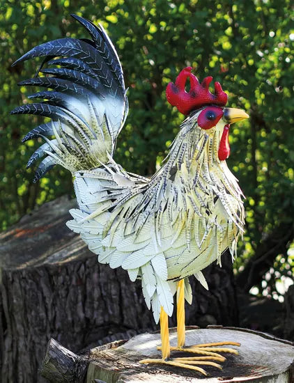 Die Gartenfigur „Hahn Fritz“ ist eine Hahnskulptur aus Metall mit detailreichem Gefieder, die im Freien auf einem Baumstumpf steht.