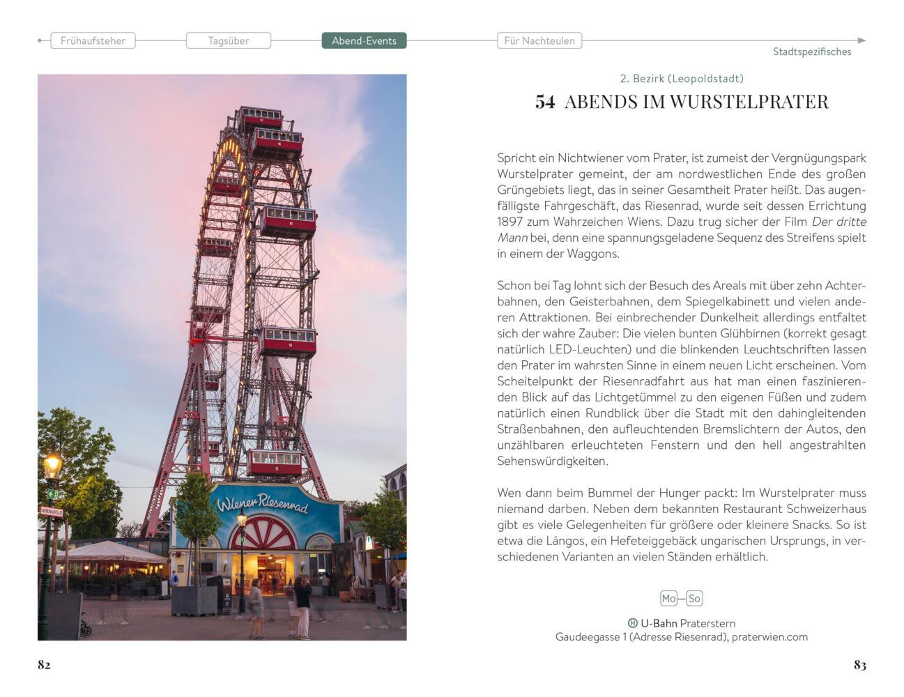 Ein großes, beleuchtetes Riesenrad steht in der Abenddämmerung in einem Vergnügungspark mit einem Restaurant darunter.