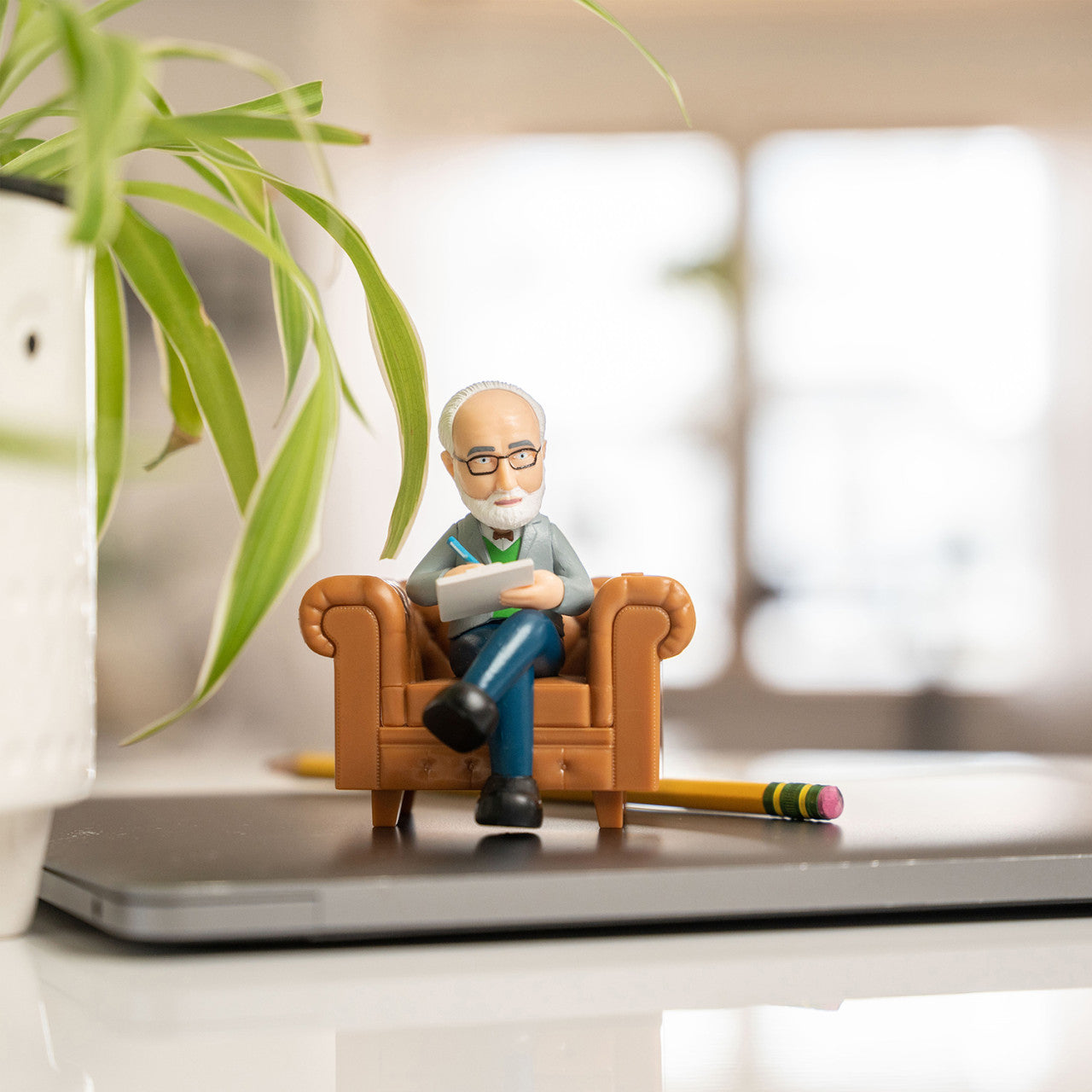 Der Schreibtisch-Psychologe ist eine kleine Figur eines älteren Mannes, der auf einem Sofa liest, perfekt für Ihren Schreibtisch, Laptop oder Arbeitsplatz.