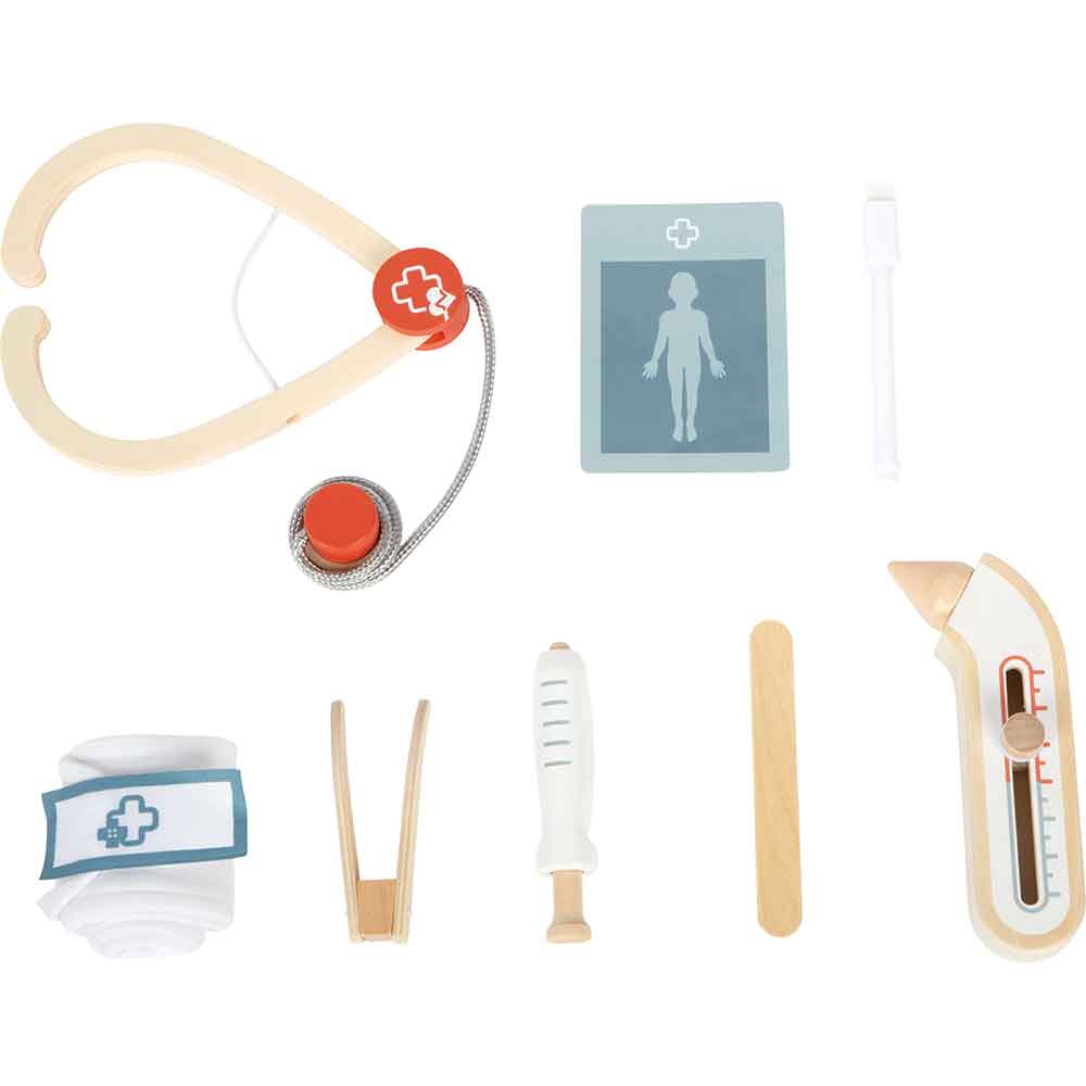 Medizinisches Spielzeugset mit Holzstethoskop, Verband, Thermometer, Spritze, Zungenspatel, Pinzette, Reflexhammer und Röntgenkarte auf weißem Hintergrund.