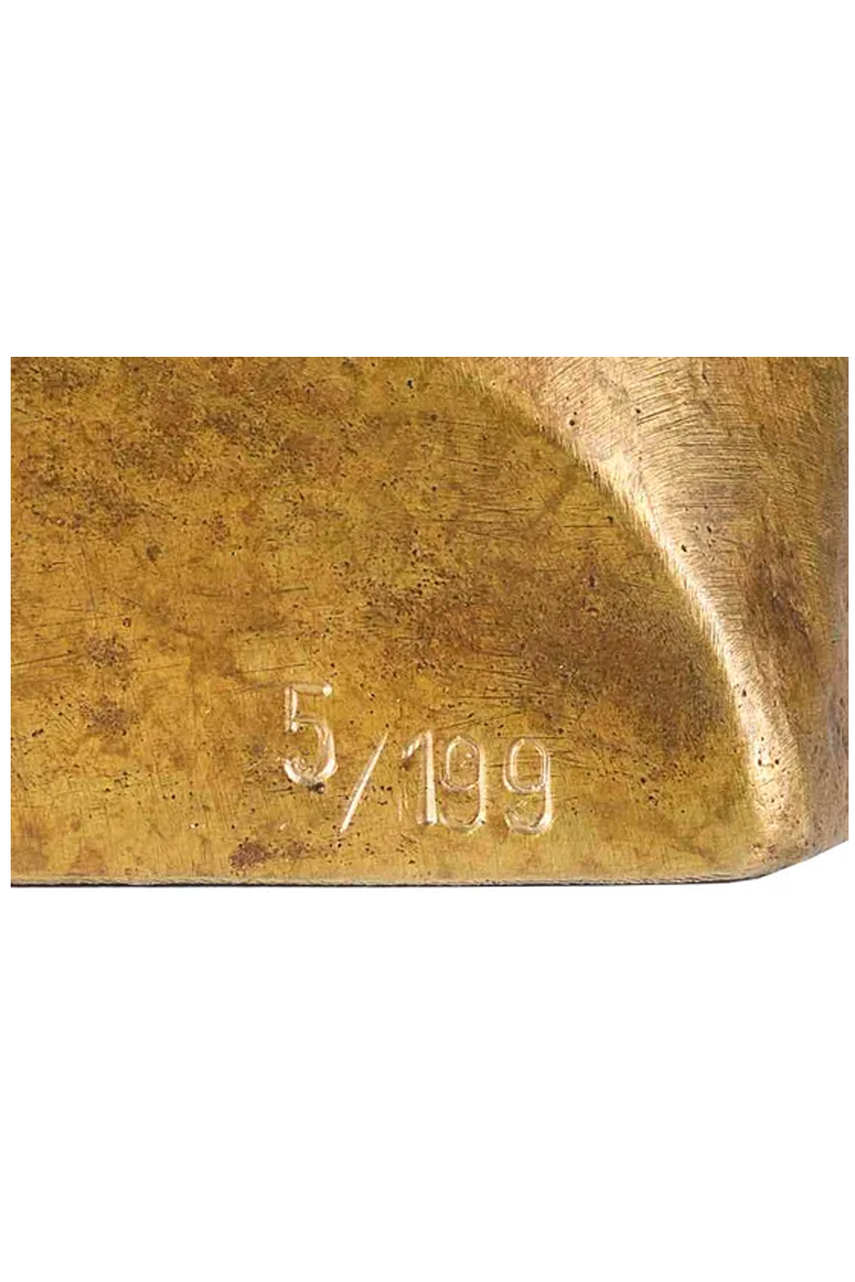 Nahaufnahme einer Messing- oder Bronzeoberfläche mit der eingravierten Nummer 5/199.