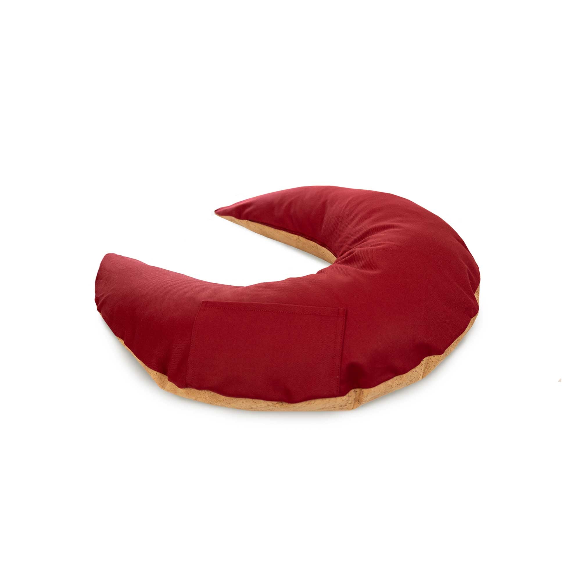 Rotes, sichelförmiges Kissen mit geschwungenem Muster und einer kleinen Tasche auf einer Seite, auf weißem Hintergrund.