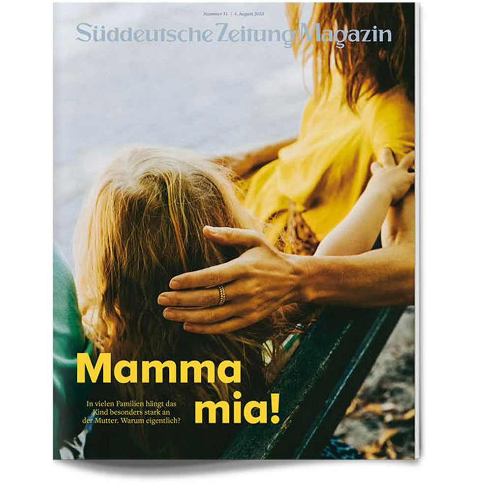 Eine Frau und ein Kind sitzen eng beieinander auf einer Bank, von hinten gesehen, mit dem Text "Mamma mia!" in Gelb.