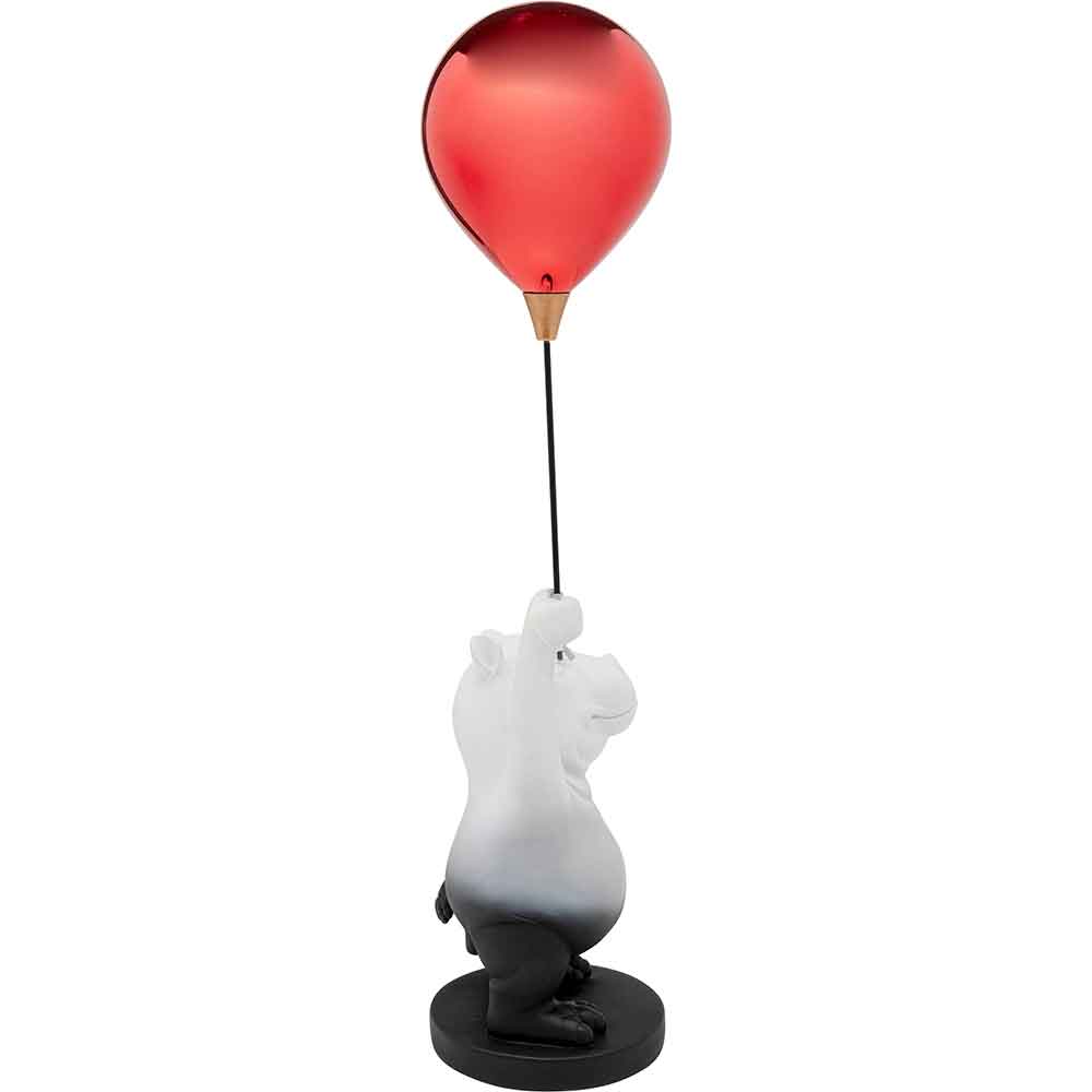 Eine Bärenfigur, die einen roten Luftballon an einer Schnur hält, steht aufrecht auf einem runden Sockel.