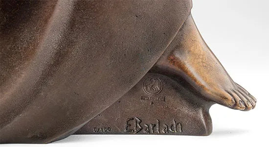Nahaufnahme einer Bronzeskulptur, die einen Fuß und die auf dem Sockel eingravierte Signatur des Künstlers E. Barlach zeigt.
