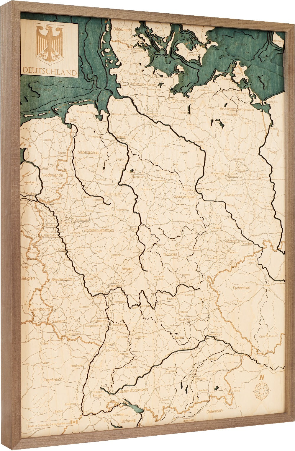 Hölzerne Deutschlandkarte mit eingravierten Grenzen, Städten und Flüssen, in Holz gerahmt mit dem deutschen Wappen.