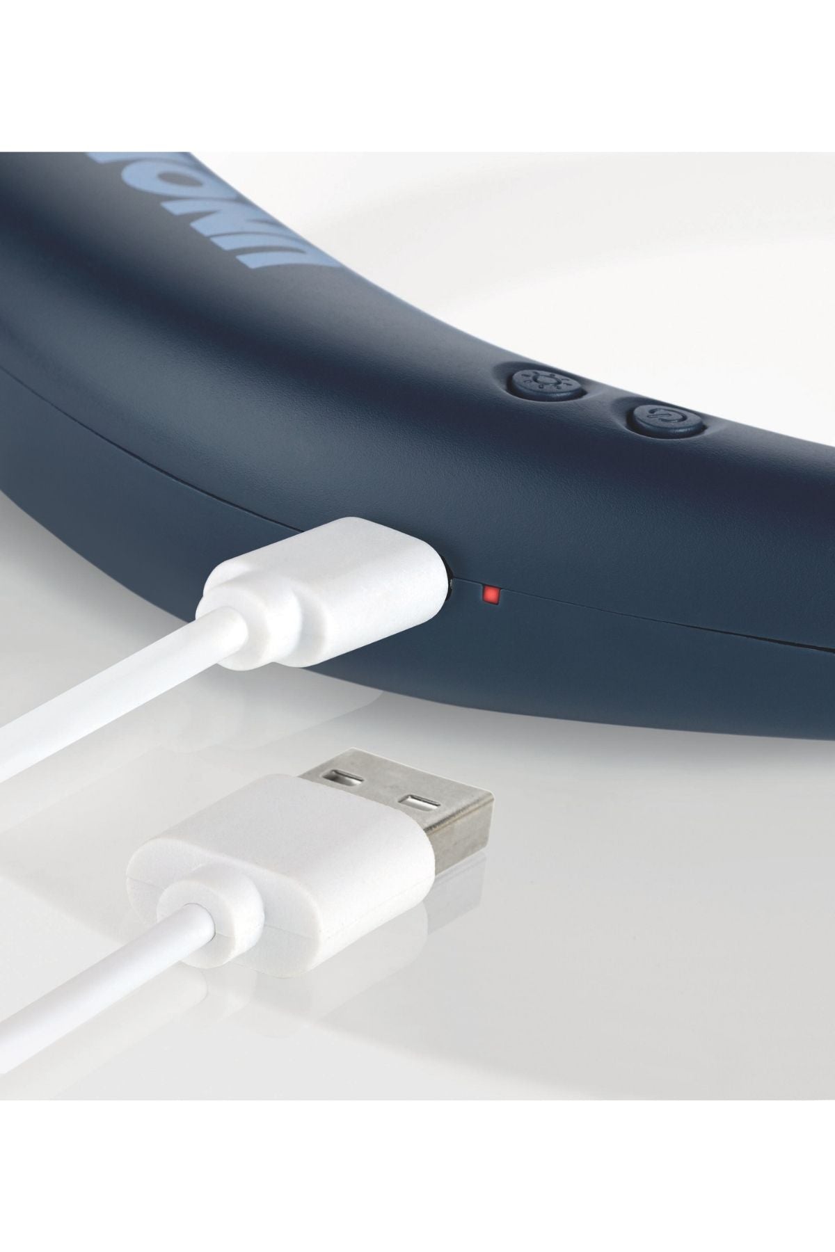 Nahaufnahme eines weißen USB-Kabels, das an ein dunkles elektronisches Gerät angeschlossen ist, wobei neben dem Anschluss ein kleines rotes Lämpchen zu sehen ist.