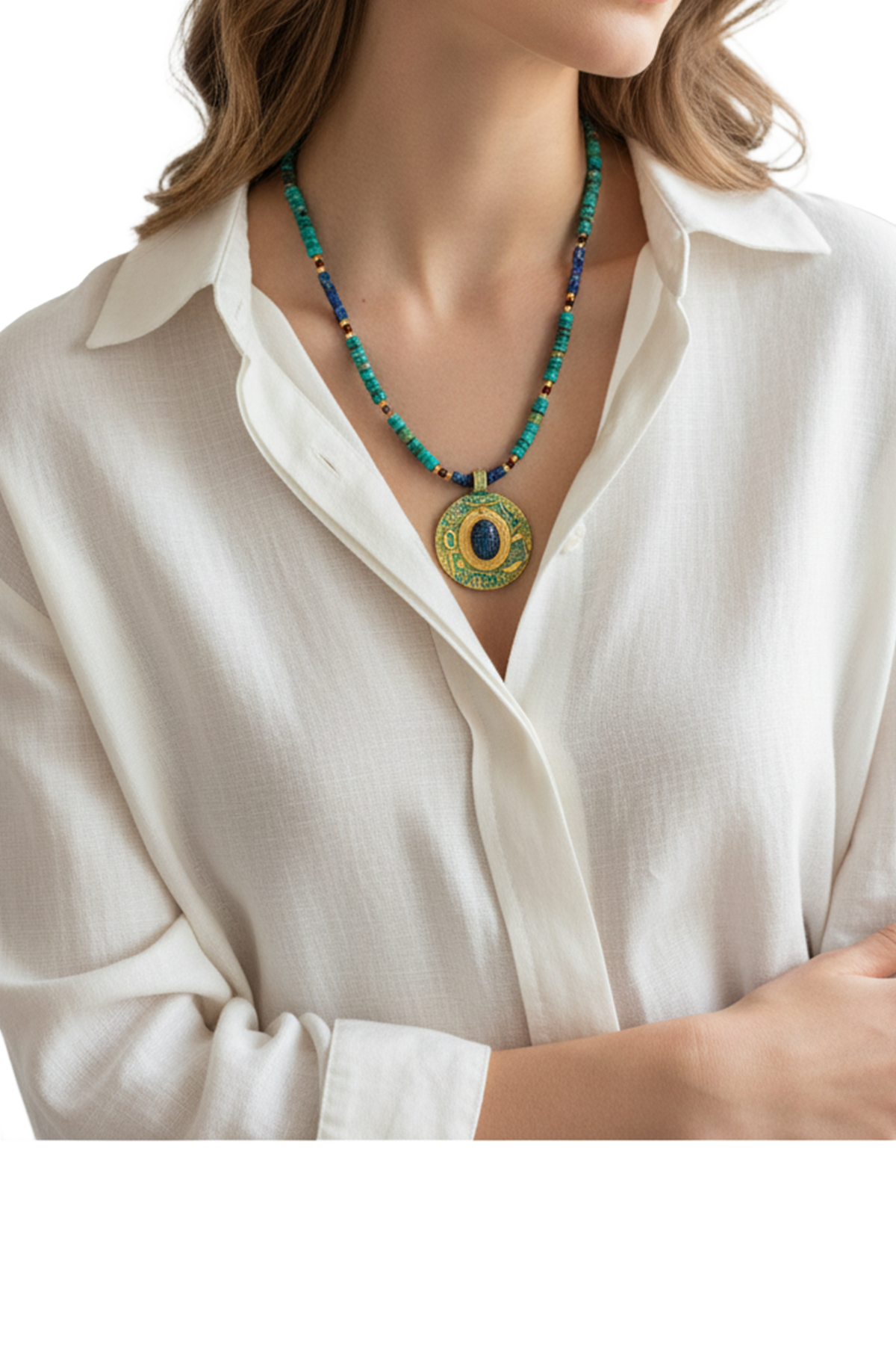 Perlenkette mit einem großen, verzierten runden Anhänger in Gold und Blau mit einem altägyptischen Skarabäus an einem Hals einer Dame mit weißer Bluse