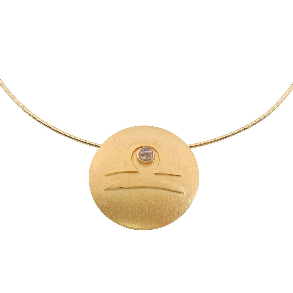 Petra Waszak: Sternzeichen-Collier „Waage“ (24.09.-23.10.) – Goldene Halskette mit einem runden Anhänger mit dem Sternzeichen Waage und einem kleinen Edelstein oben in der Mitte.