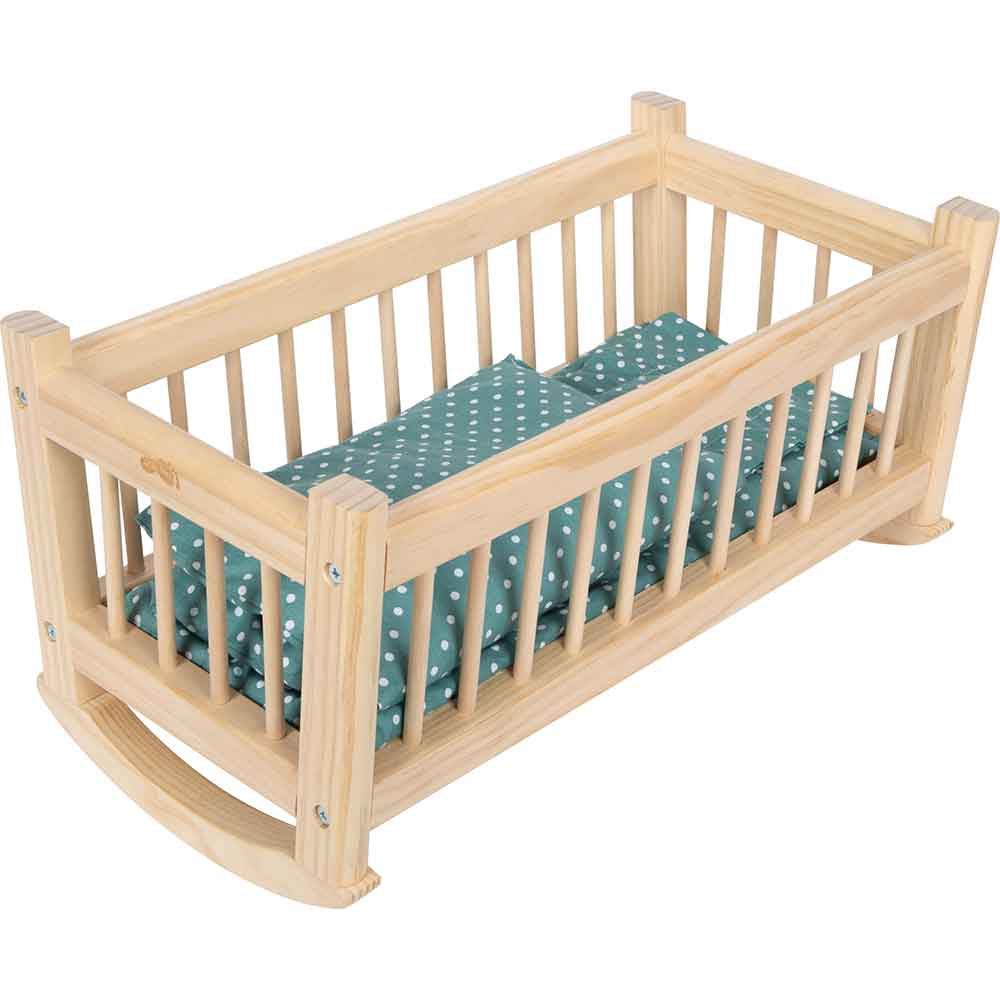 Holzspielzeugwiege mit vertikalen Latten und geschwungenem Schaukelsockel, die ein grünes Kissen und eine Decke mit weißen Tupfen enthält.