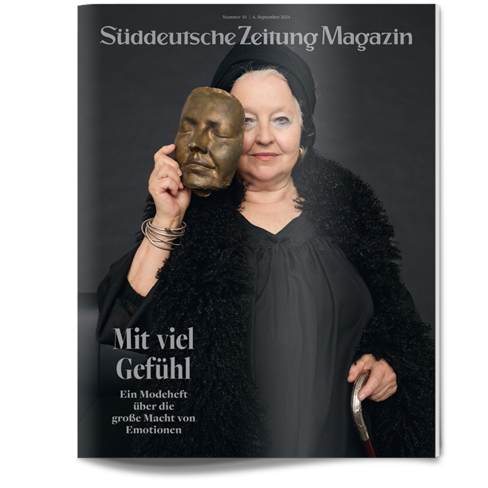 Ältere Frau in Schwarz hält eine Bronzemaske vor ihr Gesicht auf dem Cover des Süddeutsche Zeitung Magazins.