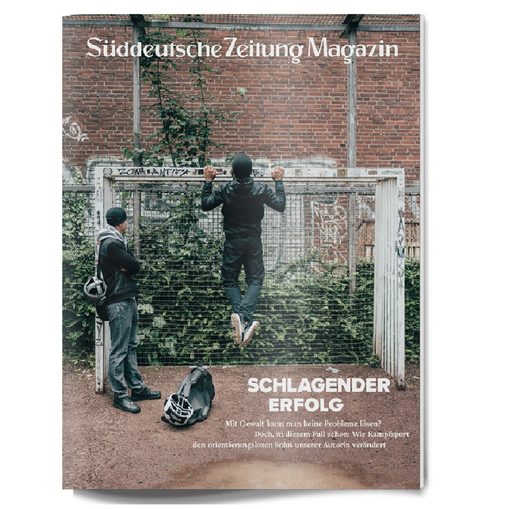 Zwei Jungen vor einem Fußballtor; der eine macht Klimmzüge, während der andere zuschaut, Taschen auf dem Boden.