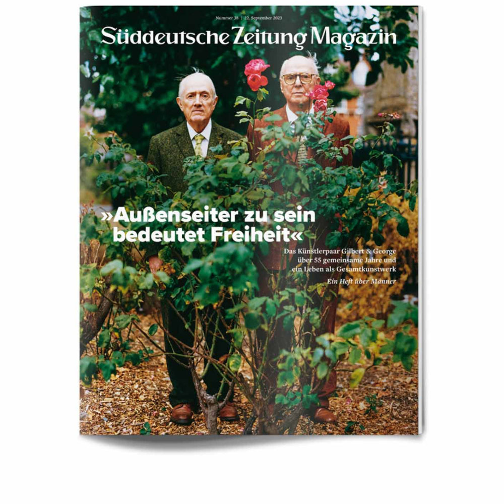 Auf dem Titelbild des Süddeutsche Zeitung Magazins stehen zwei ältere Männer in Anzügen in einem Garten, eingerahmt von Rosensträuchern.