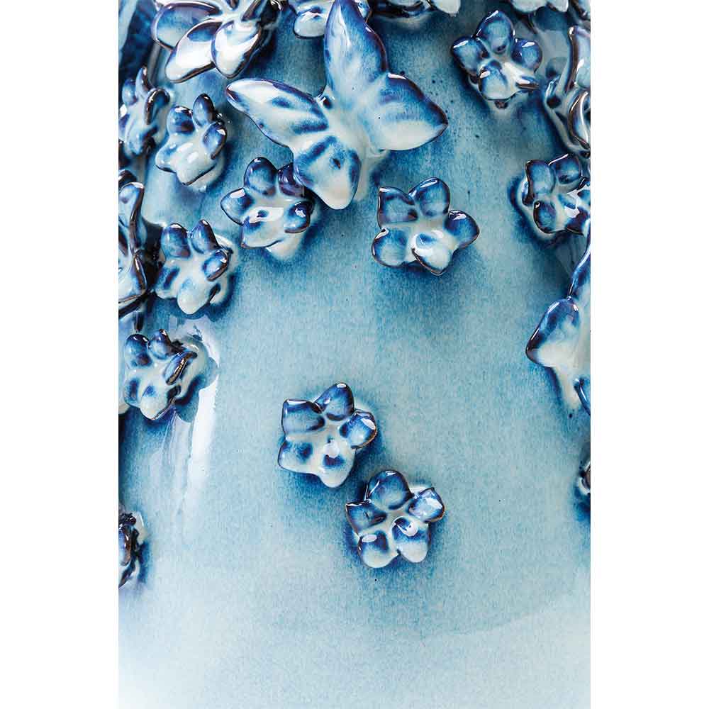 Blaue und weiße Keramikoberfläche mit erhabenen Schmetterlings- und Blumenmotiven in glänzender Ausführung.