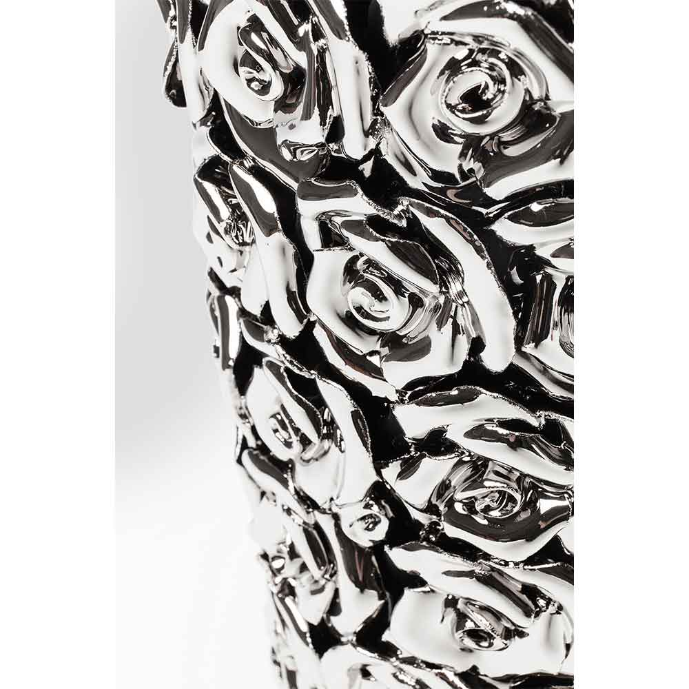 Nahaufnahme einer silberglänzenden Vase mit erhabenen Rosenblüten.