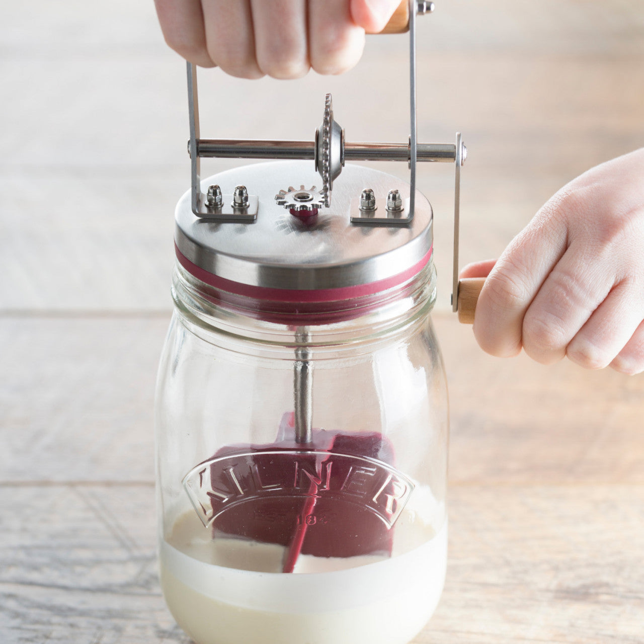Durch Drehen der Kurbel an der Butterfass-Buttermaschine von Butter Fass (1 Liter) wird aus Sahne Butter hergestellt.