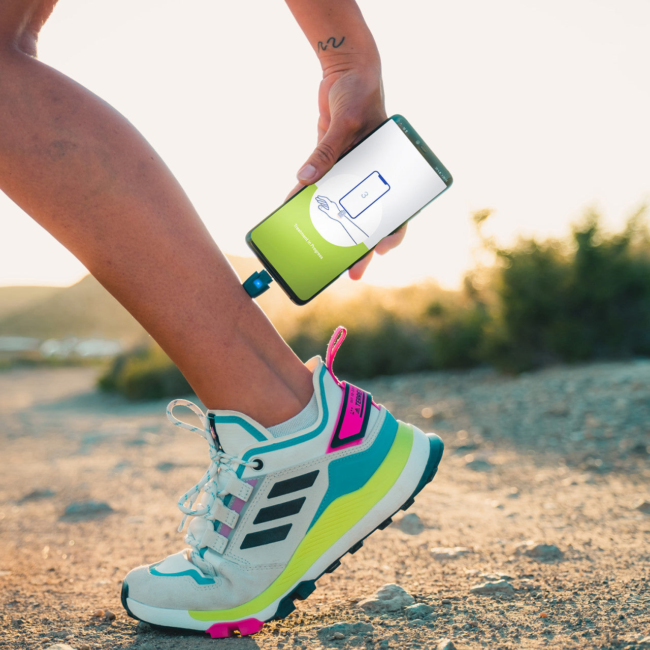Im Freien schließt man sein Smartphone an das Insektenstichheiler heat it classic Lightning-Gerät an, auf dem Display erscheint eine Fitness-App.