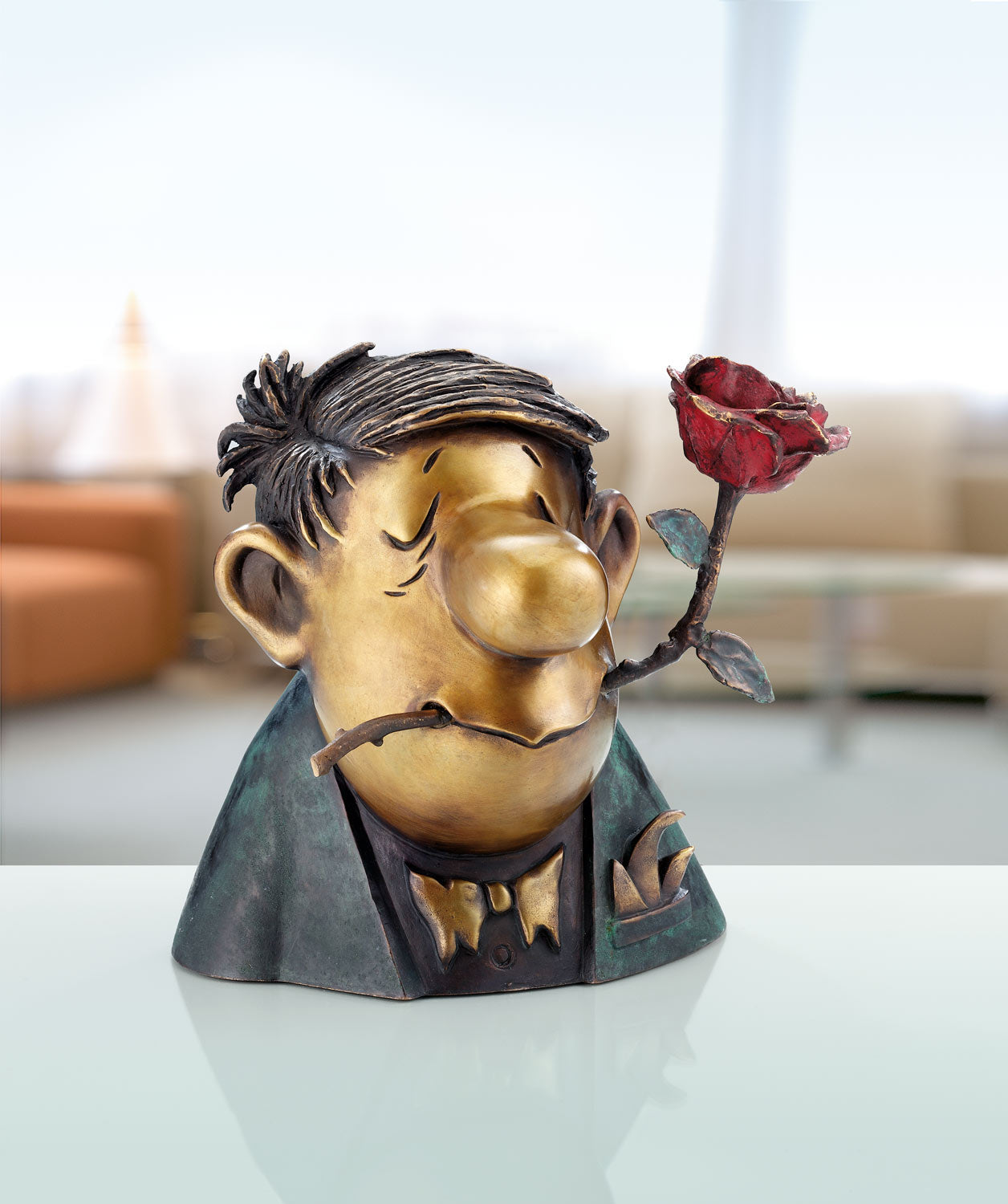 Eine skurrile Skulptur eines Mannes mit einer Rose im Mund, auf einem Tisch in einem modernen Wohnzimmer.