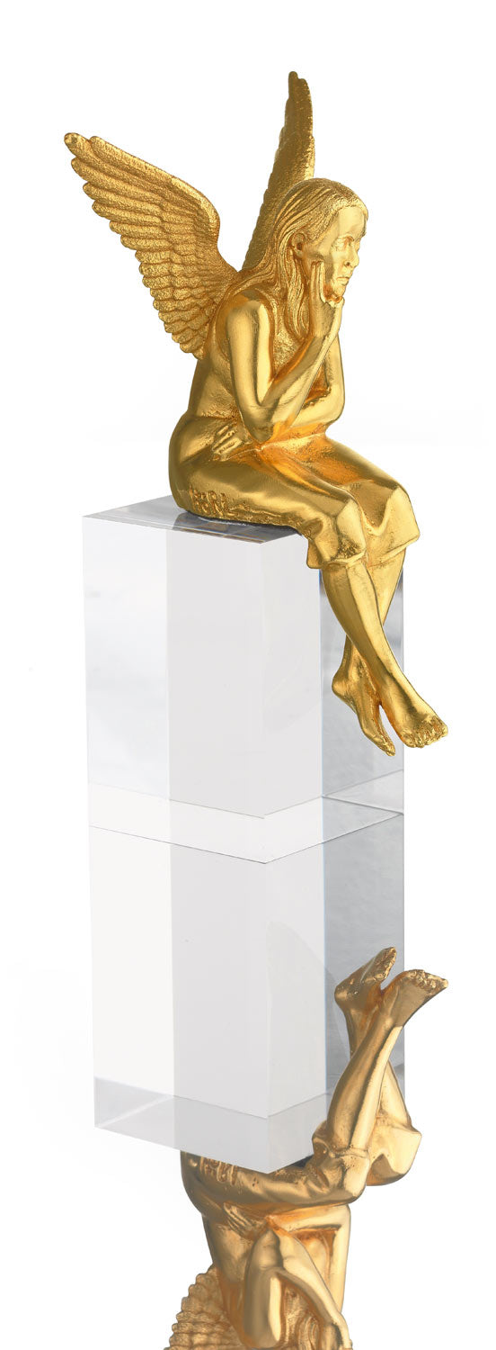 Goldene Engelsstatue, die auf einem durchsichtigen rechteckigen Block sitzt, darunter ist ihre Spiegelung sichtbar.
