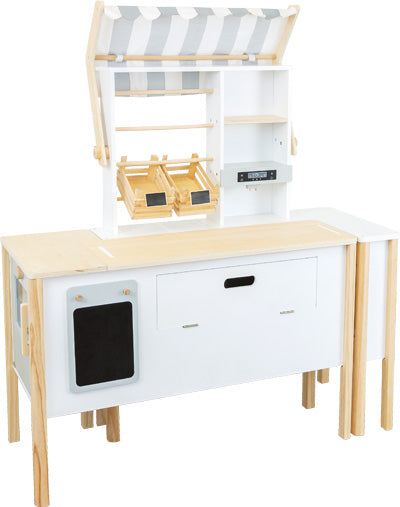 Der Kaufladen und Kinderküche Fresh verfügt über weiße Paneele, ein gestreiftes Vordach, Regale und Obst- und Gemüsebehälter im Marktstil.