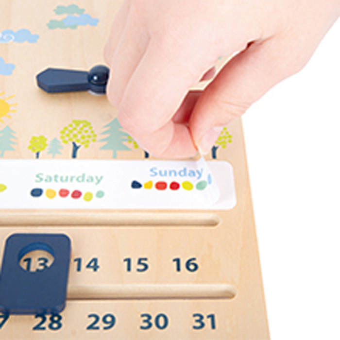 Auf der Lernuhr mit Kalender „Educate“, einem hölzernen Kalender mit Wochentagen und Zahlen, bewegt ein Zeiger einen Zeiger.