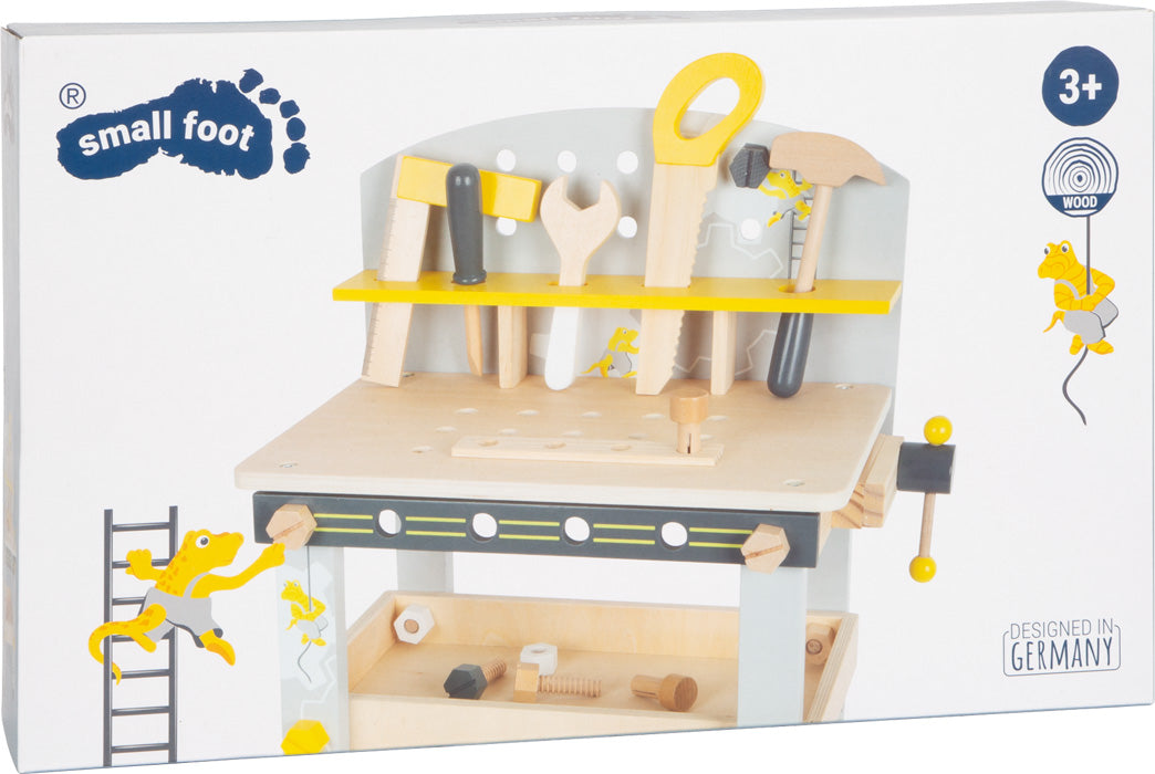 Die Werkbank kompakt „Miniwob“ ist ein Spielzeug-Werkbank-Set aus Holz mit Werkzeugen auf einem Regal, geeignet für Kinder ab 3 Jahren, mit gelben Fröschen auf der Verpackung.