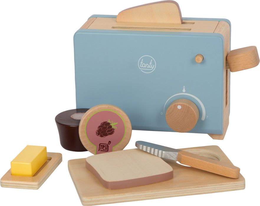 Toaster-Set „lecker“ bestehend aus einem Holztoaster, Brot, Butter, Marmelade, Messer und Schneidebrett auf weißem Hintergrund.