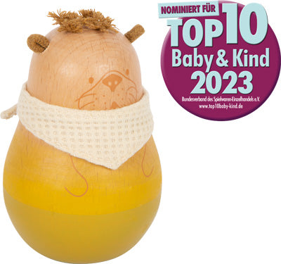 Das Baby Stehaufspielzeug „Seaside“ ist ein Holzspielzeugtier mit weißem Schal und einem Top 10 Baby & Kind 2023-Nominierungsabzeichen in deutscher Sprache.