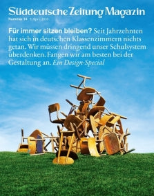 Ein Haufen hölzerner Schulstühle und -tische, die wahllos auf dem Gras gestapelt sind, mit blauem Himmel im Hintergrund.