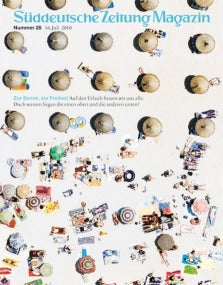 Luftaufnahme von Menschen, die sich an einem Strand mit Sonnenschirmen und Handtüchern sonnen, abgebildet auf einem Zeitschriftencover.