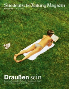 Frau im Badeanzug liegt auf einem Handtuch im Gras und liest ein Buch; Titelbild des Süddeutsche Zeitung Magazins.