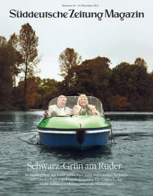 Zwei Menschen lächeln, während sie auf einem Fluss Boot fahren, mit Bäumen im Hintergrund und einem Zeitschriftentitel über ihnen.