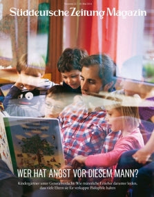 Ein Mann liest einer Gruppe kleiner Kinder, die alle dicht beieinander sitzen und aufmerksam zuhören, ein Bilderbuch vor.