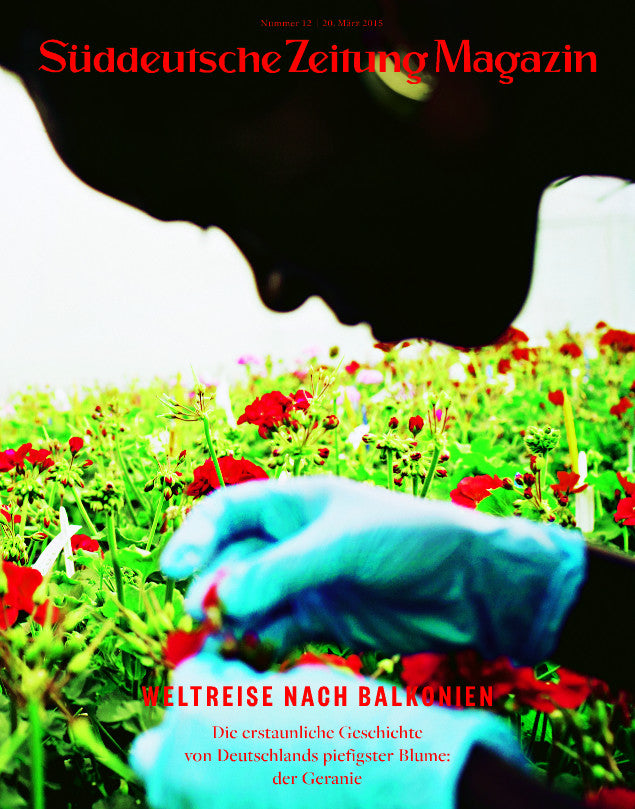 Eine Person mit blauen Handschuhen pflegt rote Blumen; Süddeutsche Zeitung Magazin ist der Titel auf Deutsch.